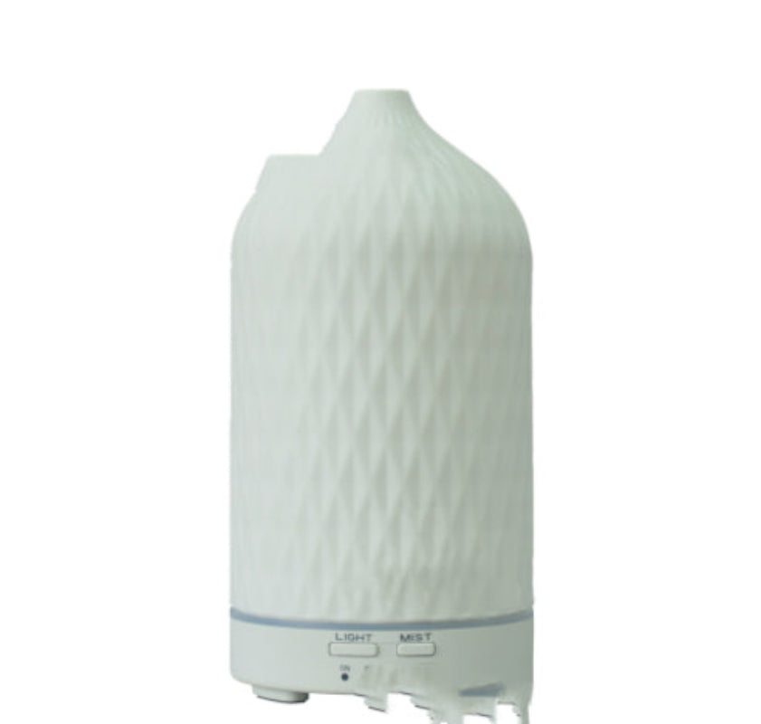 White ceramic aroma diffuser with textured ridges and mist/light buttons on base