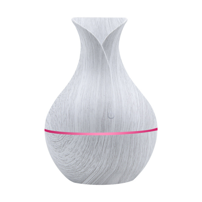 White wood-grain aroma diffuser with pink-magenta LED light band and power button.