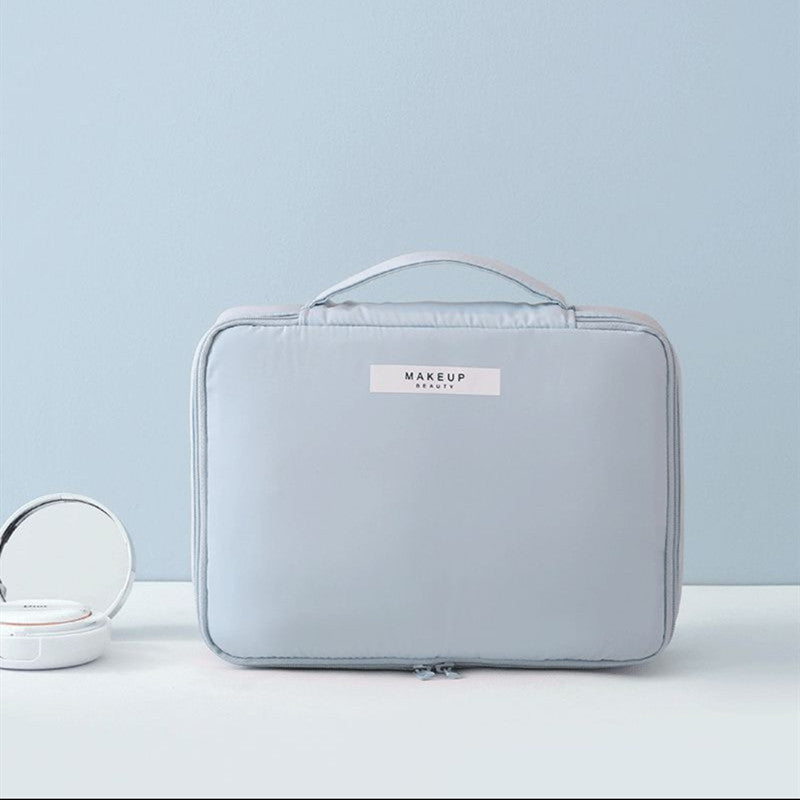 Light blue compact makeup travel pouch with front label and zip closure