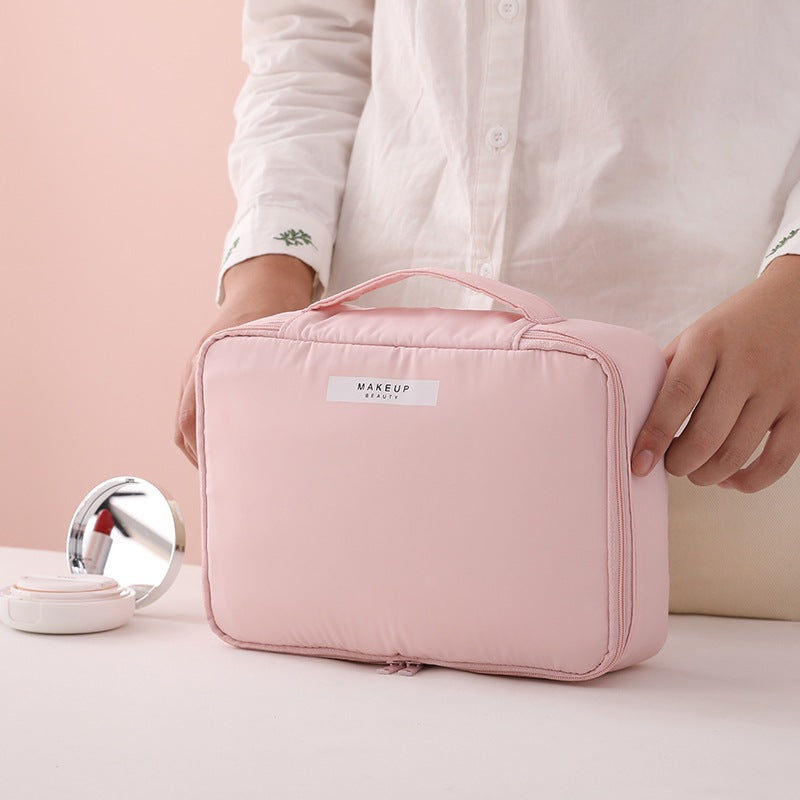 Pink compact makeup travel pouch with front label and zip closure