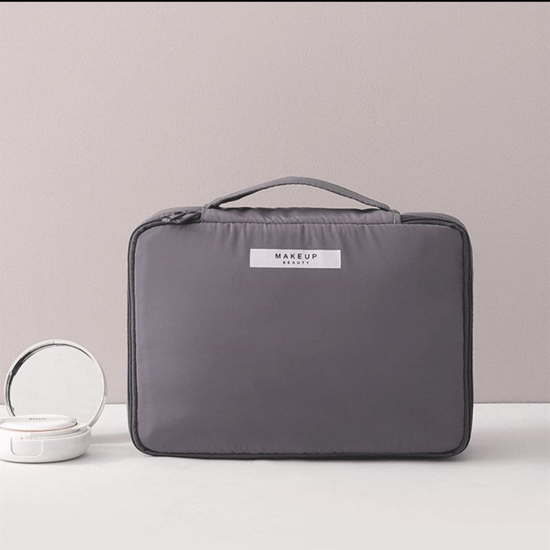 Charcoal gray compact makeup travel pouch with top handle and zip closure