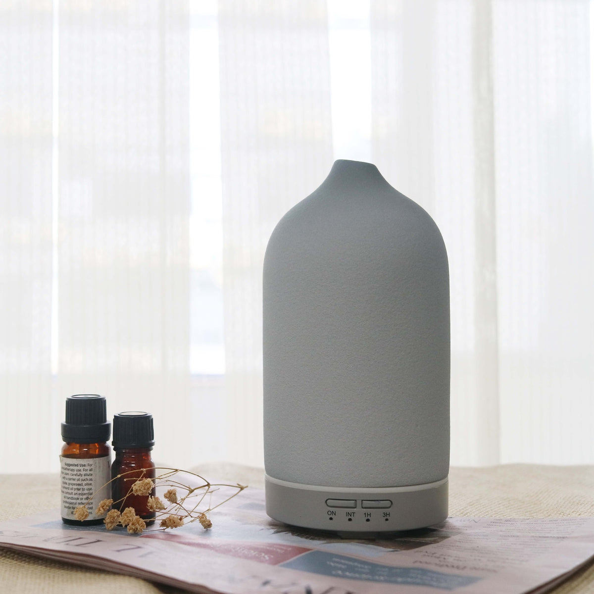 Light gray ceramic aroma diffuser with rounded top and base control buttons