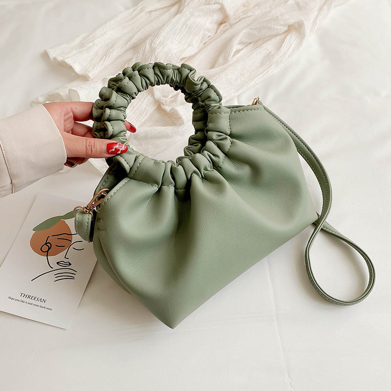 Green ruched-top crossbody travel bag with drawstring rim and adjustable strap