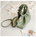 Green ruched drawstring crossbody bag with adjustable strap and gold-tone hardware