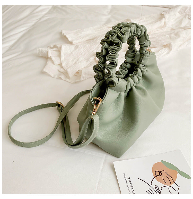 Green ruched drawstring crossbody bag with adjustable strap and gold-tone hardware