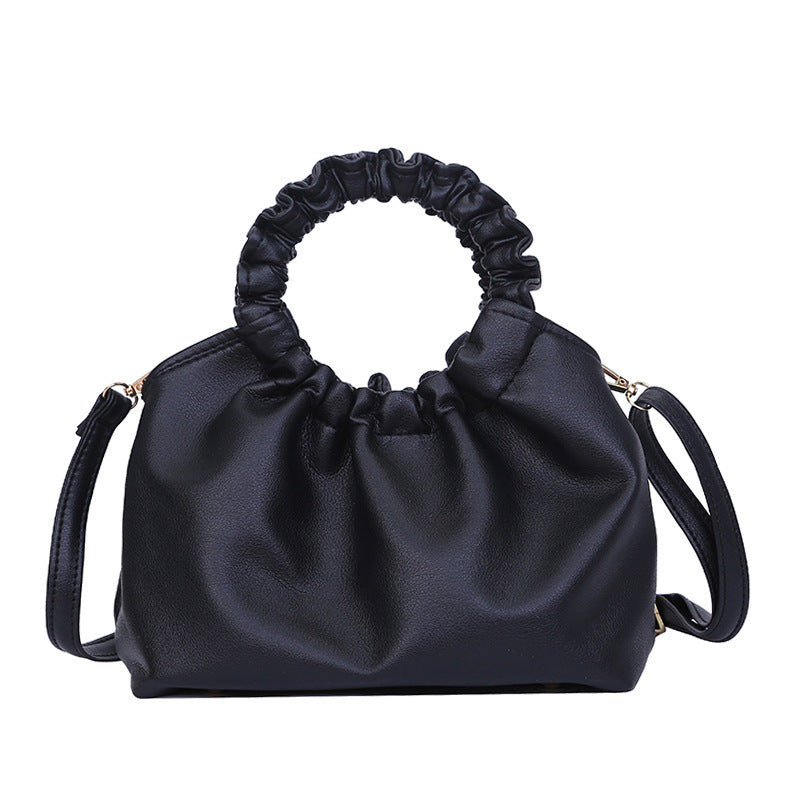 Black ruched-top crossbody travel bag with shoulder strap and gold-tone hardware