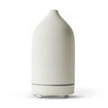 White ceramic aroma diffuser with tapered bottle shape and rounded base feet