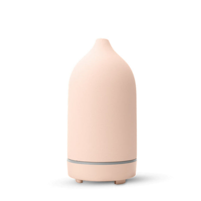 Ceramic aroma diffuser in light pink, smooth bottle with base and small feet