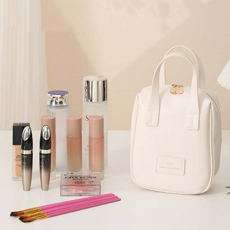 White travel vanity bag with top handles, standing open with makeup bottles inside.