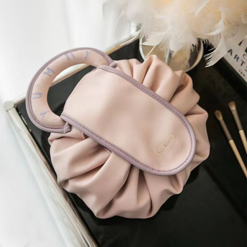 Light pink drawstring wash bag with oval loop handle and Tea Break patch