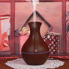 Wood grain aroma diffuser, dark teardrop shape with glowing power light and mist stream
