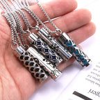 Stainless steel aroma pendant with blue star-like inlay and decorative cutouts on cylinder