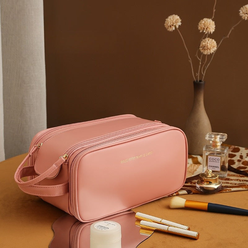 Pink structured travel vanity case with zip closure and adjustable crossbody strap