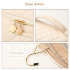 Vanity bag close-up: quilted front, gold zipper pulls, and curved top handle