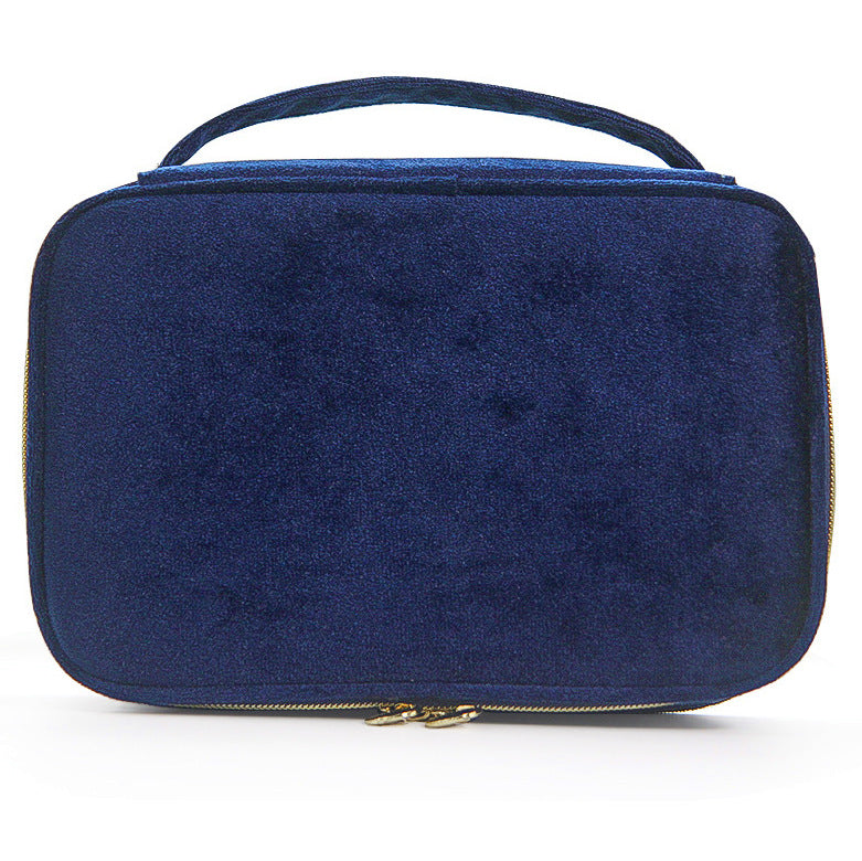 Soft travel cosmetic case in dark blue with top handle and gold zipper pull