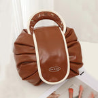 Brown drawstring wash bag with white trim, oval loop handle, and Tea Break patch