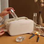 White structured travel vanity case with zip front and wrist strap, cosmetics bottle inside