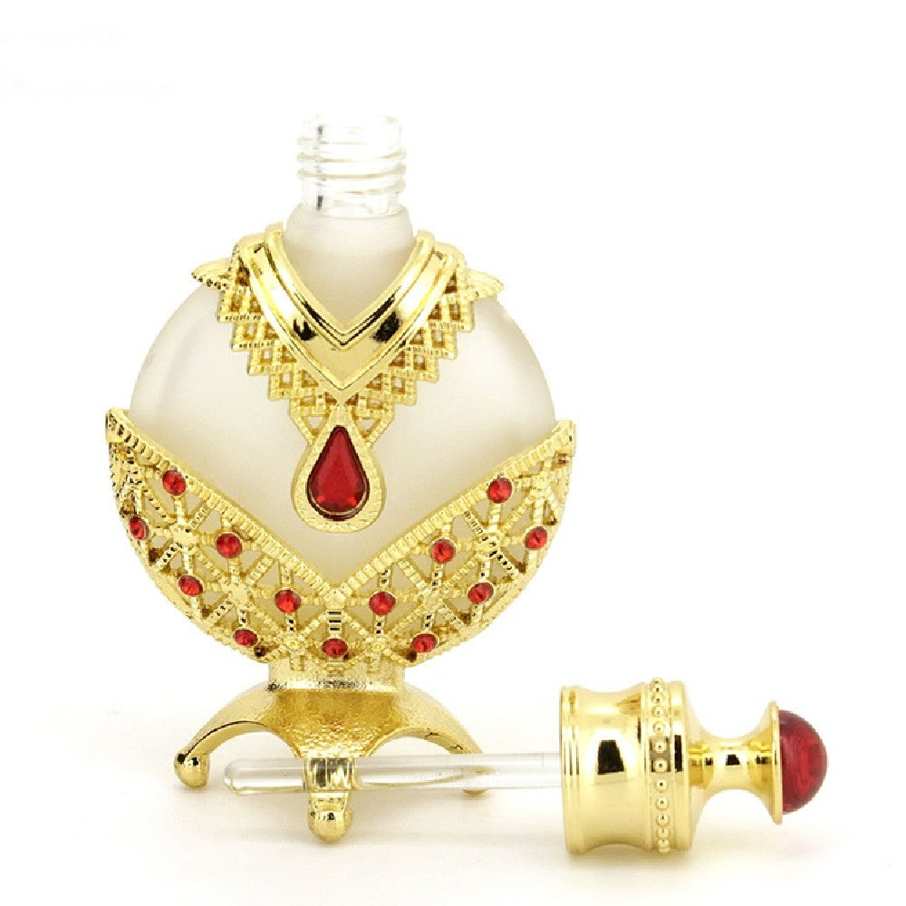 Perfume oil vial with gold trim, red teardrop emblem, white body and clear dispensing tube