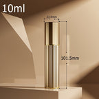 Gold-toned travel perfume atomiser with ribbed cylindrical body and hinged spray cap