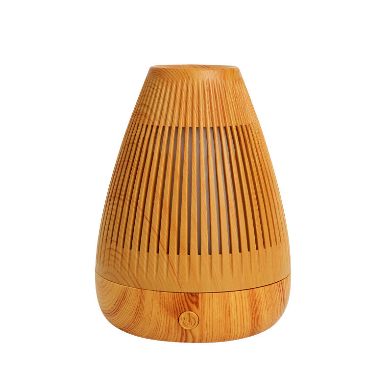 Essential oil diffuser with light wood grain body and vertical slat vents, LED base button