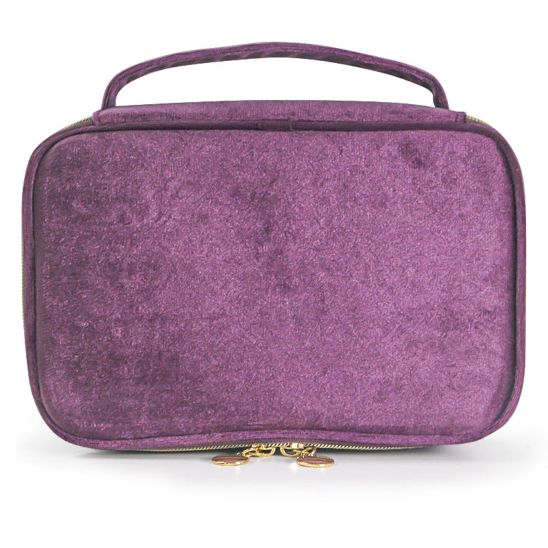 Soft travel cosmetic case in purple with top handle and gold zipper pull