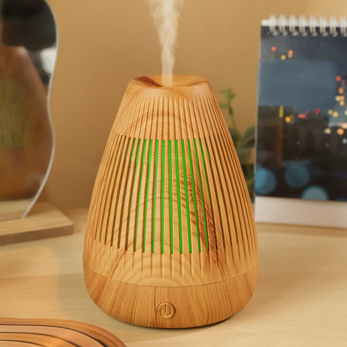 Ultrasonic essential oil diffuser in light wood grain with green LED glow and rising mist