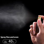 Gold travel perfume atomiser held in hand, fine mist spraying from the nozzle