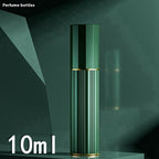 Green travel perfume atomiser with ribbed metal body, gold trim, and capped top