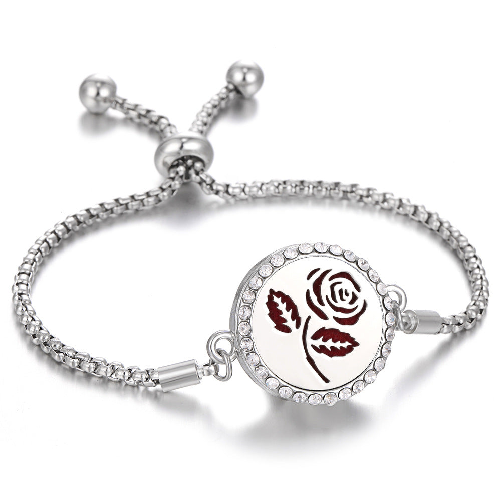 Silver tone aroma bracelet with rose-and-leaf motif charm