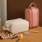 Pink structured travel vanity case with top handle, zip front panel, and side compartments