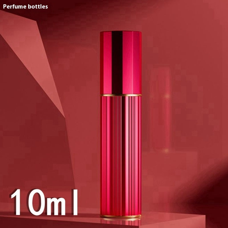 Red travel perfume atomiser with ribbed metal body and gold-toned base trim