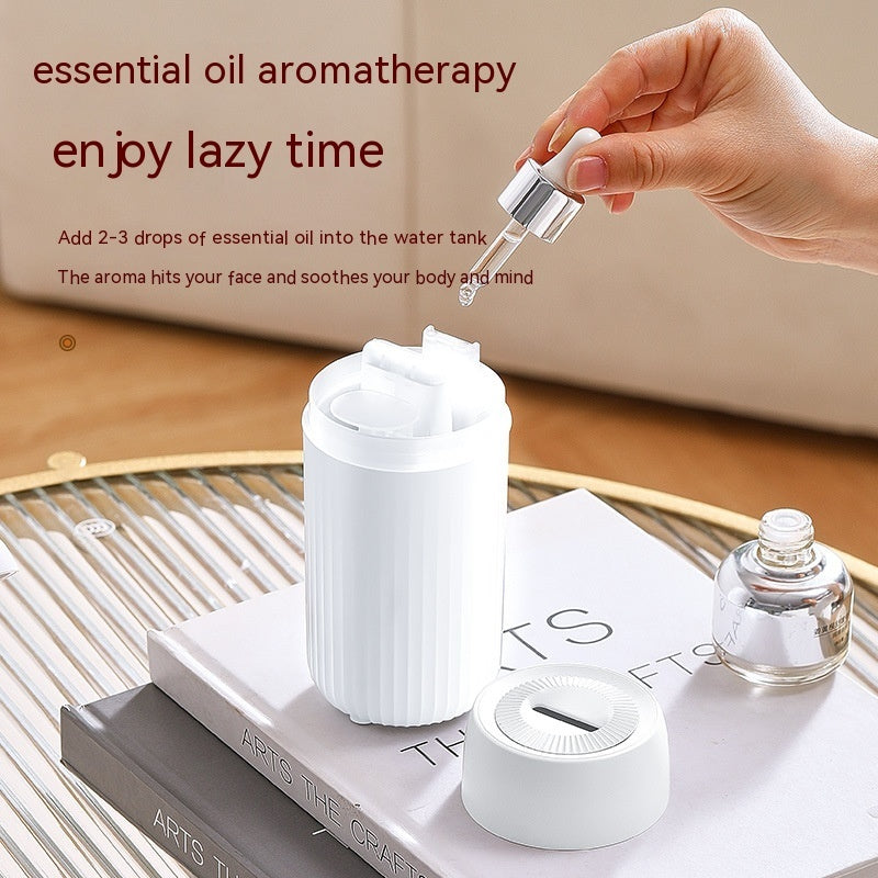 White aroma diffuser with essential oil dropper bottle, on display stand.