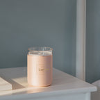 Pink candle-style aroma diffuser jar with clear lid and front label