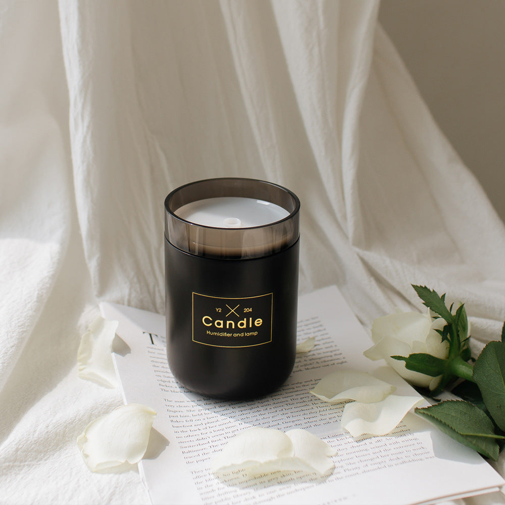Black candle-style aroma diffuser jar with clear lid and gold logo
