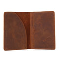Open leather passport cover showing two sections and center seam, tan-brown with stitching