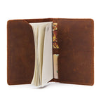 Open leather passport cover with card and document pockets, tan-brown interior view