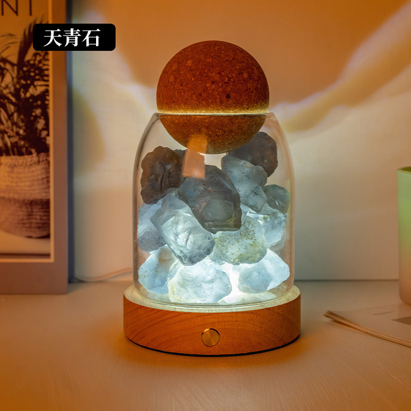 Crystal diffuser night light with blue-gray chunks and glowing salt-stone cap on wooden base