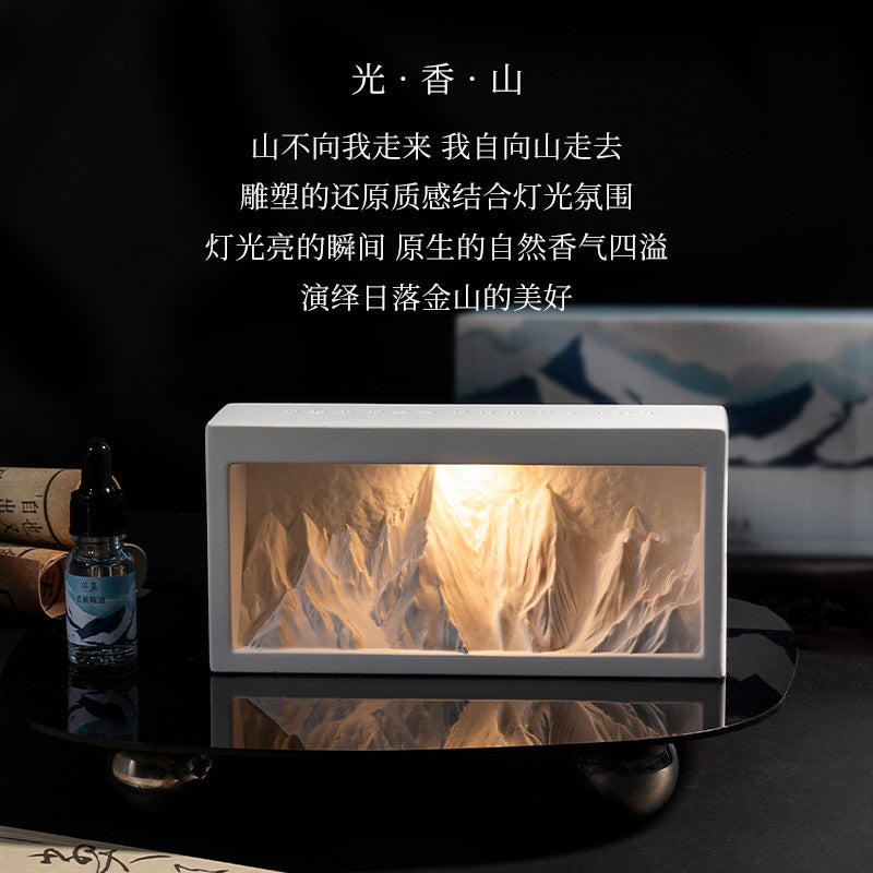Rectangular crystal diffuser with lit mountain-style insert and small essential oil bottle