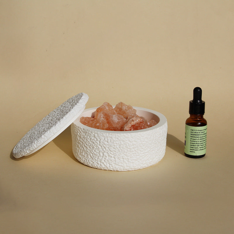 Stone crystal diffuser with orange crystals in a white textured round lid and base