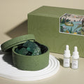 Natural stone crystal diffuser with green bowl and teal crystals, with two small bottles