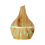 Wood grain aroma diffuser with teal LED light ring and power button, light wood finish.