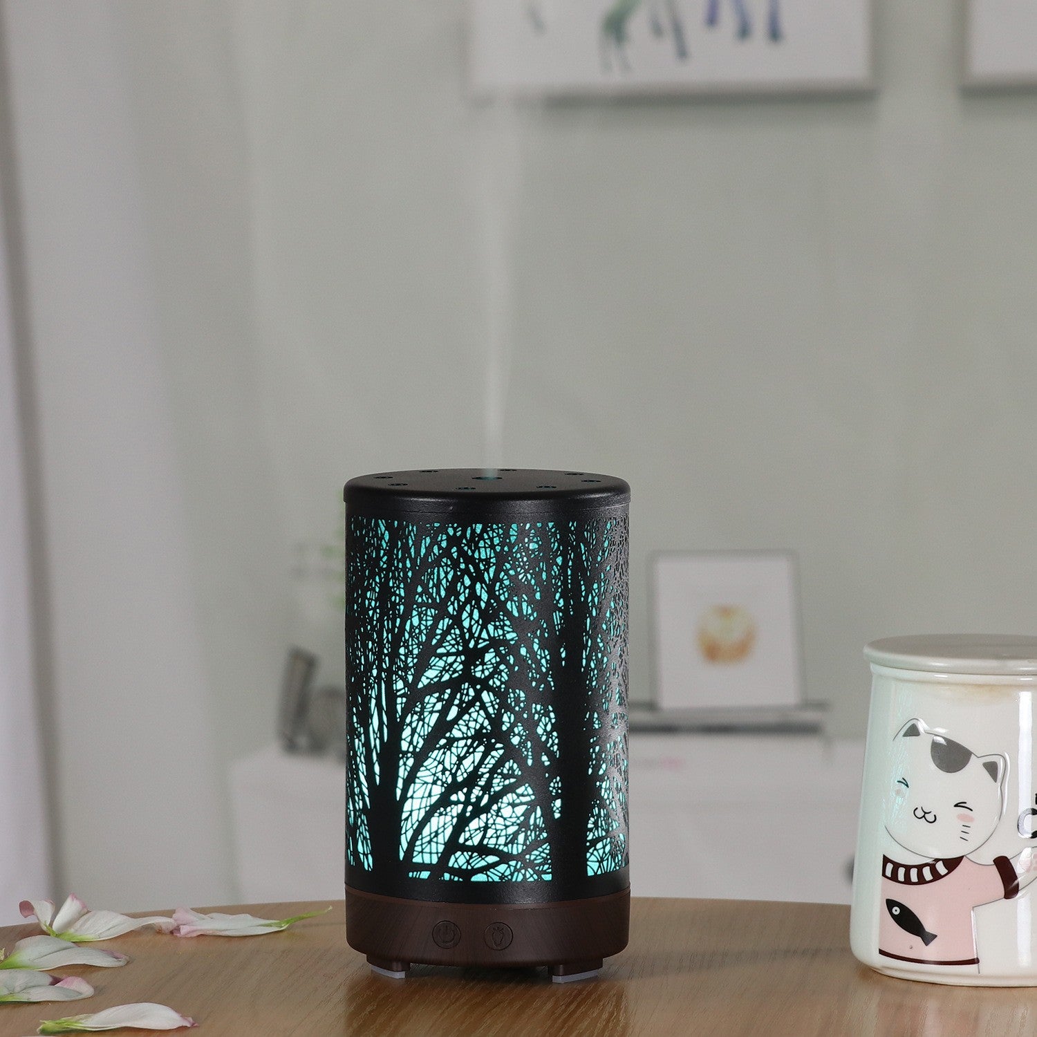 Mini aroma diffuser with dark base, glowing forest light pattern, top vents
