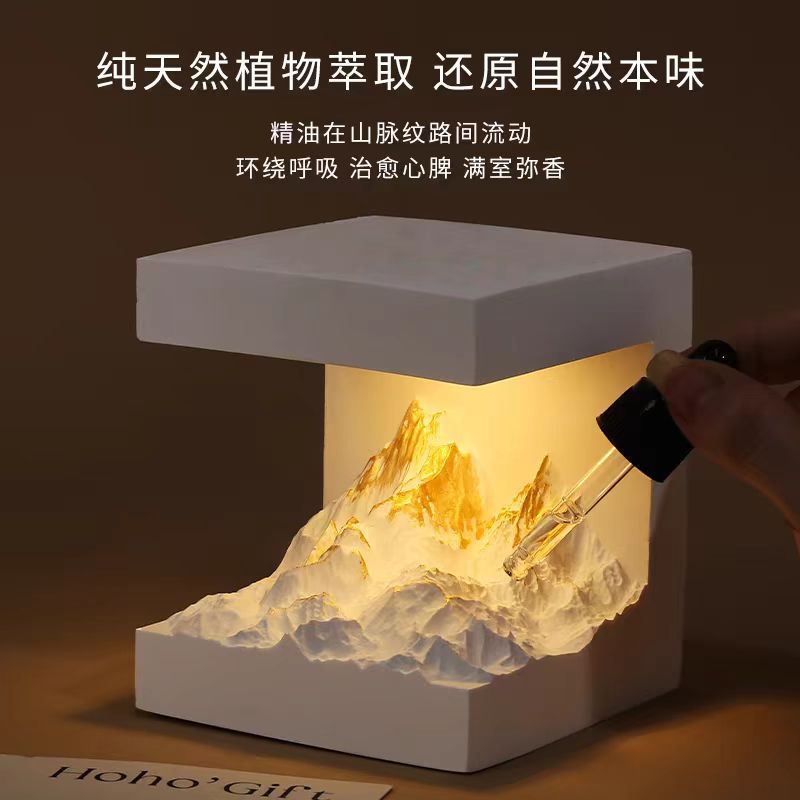 White cube aromatherapy lamp casting warm light over a crumpled scent insert