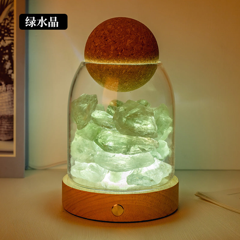 Crystal diffuser night light with green crystal chunks and glowing salt-stone cap on wooden base
