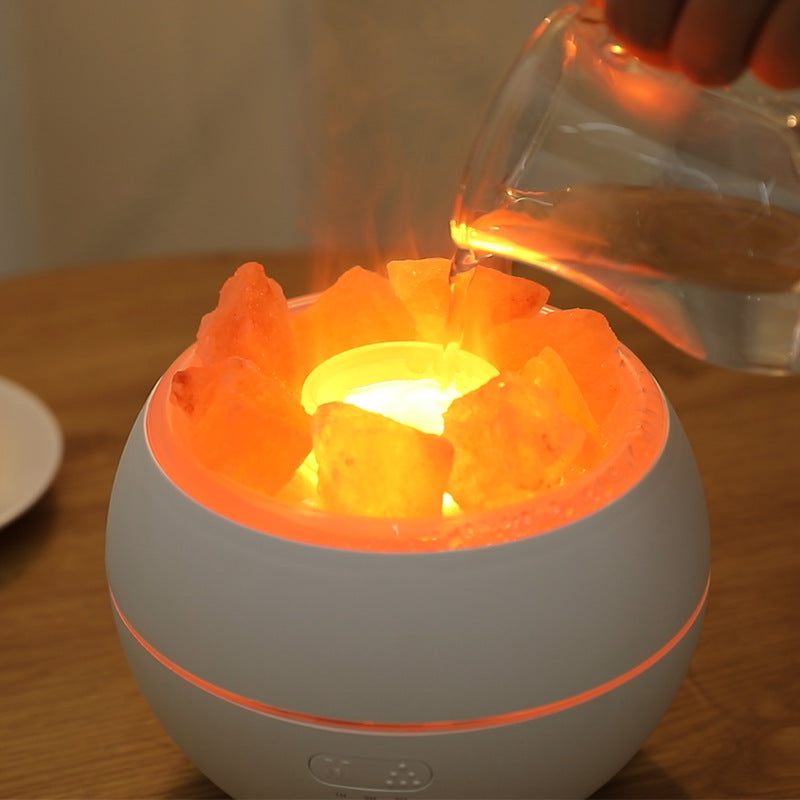 White salt stone crystal aroma diffuser with orange glowing crystals and pouring bottle