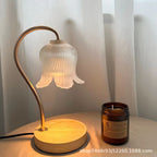 Wood-grain aroma diffuser with lit bell-shaped glass shade and amber candle jar on base