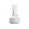 White aroma diffuser with clear glass tube and warm glowing filament