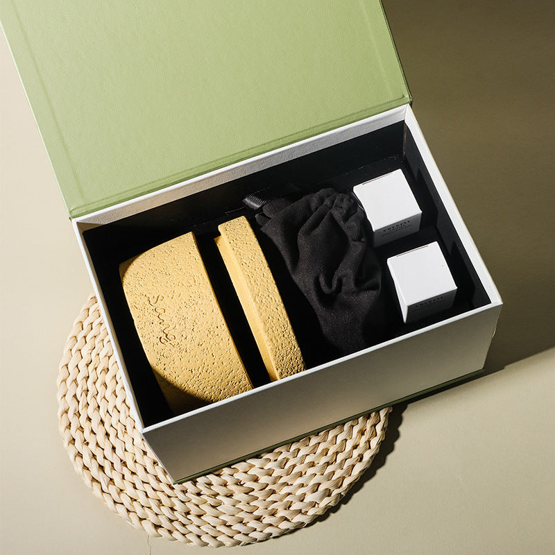 Natural stone crystal diffuser set in open box with sand-colored stones and two bottles