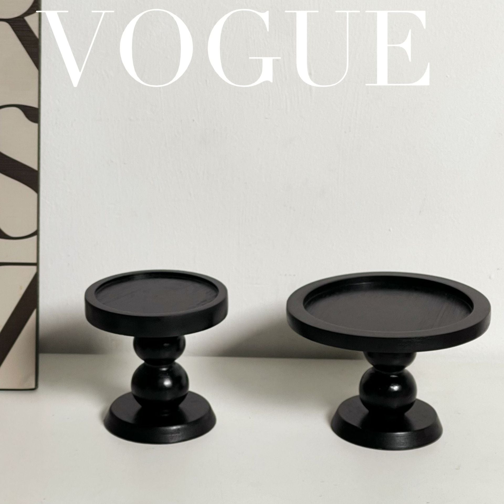 Pair of black round scent trays on pedestal bases, close tabletop view