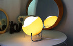 Amber glass globe table lamp on chrome stand, warm light glow
